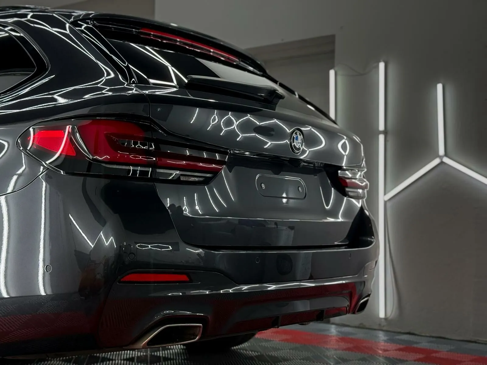Stražnji dio BMW-a serije 5 s odrazom detailing rasvjete nakon korekcije laka